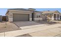 Modern two-car garage home with gray exterior and new landscaping at 15399 W Desert Hollow Dr, Surprise, AZ 85387