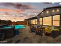 Evening view of a backyard pool and spa with patio furniture at 10737 E Simone Ave, Mesa, AZ 85212