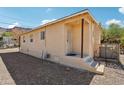 Side view of a tan house with a small porch and gravel yard at 529 W Sonora St, Superior, AZ 85173