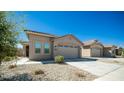 Tan house with a two car garage and landscaping at 16543 W Alameda Rd, Surprise, AZ 85387