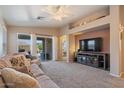 Spacious living room with beige carpeting, a sofa, and a large TV at 1448 E Poncho Ln, San Tan Valley, AZ 85143