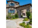 Stone house with arched entryway and landscaped grounds at 11200 E Canyon Cross Way, Scottsdale, AZ 85255