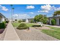 Complex exterior showing multiple buildings with walkway, landscaping, and lawn at 10912 W Coggins Dr, Sun City, AZ 85351