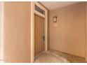 Condo entryway with a brown door and a light fixture, simple and clean at 20100 N 78Th Pl # 1107, Scottsdale, AZ 85255