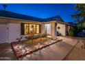 Front entrance with brick walkway, landscaping, and warm lighting at 17430 N Desert Glen Dr, Sun City West, AZ 85375