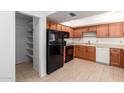 Kitchen with wood cabinets, black appliances, and pantry at 4045 E Columbine Dr, Phoenix, AZ 85032