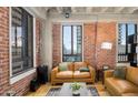 Tan leather couch in living room with exposed brick walls at 114 W Adams St # 808, Phoenix, AZ 85003