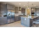 Spacious kitchen with island, stainless steel appliances, and gray cabinets at 18162 W Cielo Grande Ave, Surprise, AZ 85387