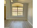 Bright living room with neutral walls, wood-look floors, and a large window at 20411 N 99Th Dr, Peoria, AZ 85382