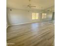 Spacious living room with light walls, wood-look flooring, and a large window at 20411 N 99Th Dr, Peoria, AZ 85382