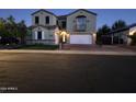 Night view of two-story home with three-car garage at 18459 W Carol W Ave, Waddell, AZ 85355