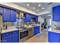 Modern kitchen with blue cabinets and stainless steel appliances at 4525 N 66Th St # 48, Scottsdale, AZ 85251