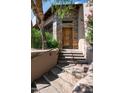 Stone steps leading to a wooden door with stone accents at 10626 E Palo Brea Dr, Scottsdale, AZ 85262