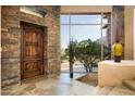 Elegant entryway with stone wall and large window at 10626 E Palo Brea Dr, Scottsdale, AZ 85262
