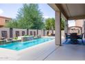 Inviting pool area with a waterfall feature and covered patio at 161 N Silverwood Dr, Casa Grande, AZ 85122