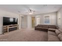 Living room with a fireplace and large TV at 17986 W Fulton St, Goodyear, AZ 85338