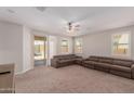 Spacious Gathering room with brown sectional sofa and sliding glass door to backyard at 17986 W Fulton St, Goodyear, AZ 85338