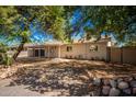 Single story home with a carport and mature trees in front at 2901 N Miller Rd, Scottsdale, AZ 85251