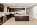 Spacious kitchen with island and dark wood cabinets at 37784 W San Sisto Ave, Maricopa, AZ 85138