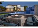 Modern firepit and seating area next to a luxury home at 6850 E Joshua Tree Ln, Paradise Valley, AZ 85253