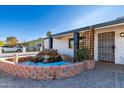 Front view of a remodeled home with a rock waterfall feature at 721 W 3Rd Pl, Mesa, AZ 85201