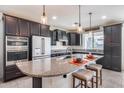Spacious kitchen with dark cabinets, granite counters, and an island at 4707 S Avitus Ln, Mesa, AZ 85212