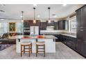 Kitchen with dark cabinets, granite island, and stainless steel appliances at 4707 S Avitus Ln, Mesa, AZ 85212
