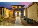 Front entry with stone accents and desert landscaping at night at 18364 N Diamond Dr, Surprise, AZ 85374
