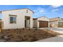 New construction home's front exterior with two-car garage and desert landscaping at 37735 W Padilla St, Maricopa, AZ 85138