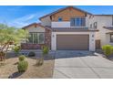 Two-story home with attached garage, landscaping, and a modern design at 10763 W Beatrice St, Avondale, AZ 85323