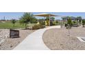 Community park with playground, shaded seating, and walking paths at 36503 W San Ildefanso Ave, Maricopa, AZ 85138