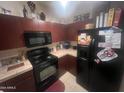 Kitchen features dark wood cabinets and black appliances at 2450 W Glenrosa Ave # 28, Phoenix, AZ 85015