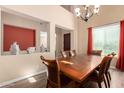 Formal dining room with a wooden table, chandelier, and red curtains at 3588 E Kaibab Pl, Chandler, AZ 85249