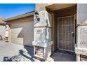 Front door entrance with security door and stone accents at 10277 N 115Th Dr, Youngtown, AZ 85363