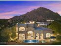 Luxury home with a pool and mountain backdrop at sunset at 10793 E La Junta Rd, Scottsdale, AZ 85255