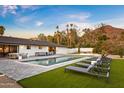 Luxury backyard oasis with a sparkling pool, ample lounge space, and mountain views at 4633 N 49Th Pl, Phoenix, AZ 85018