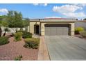 Tan two-car garage home with a manicured front yard at 22303 N Montecito Ave, Sun City West, AZ 85375