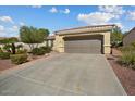 Tan two-car garage home with a manicured front yard at 22303 N Montecito Ave, Sun City West, AZ 85375