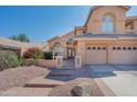 Two-story house with tan stucco exterior, two-car garage, and a fountain in the front yard at 753 E Mountain Sky Ave, Phoenix, AZ 85048