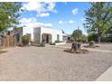 White stucco home with mature trees and gravel yard at 100 Swilling Ave, Wickenburg, AZ 85390