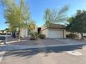 Tan colored stucco home with a white garage door and mature landscaping at 7006 E Jensen St # 83, Mesa, AZ 85207