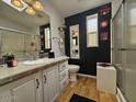 Bathroom with a walk-in shower, single sink vanity, and dark-colored walls at 8700 E University Dr # 1322, Mesa, AZ 85207