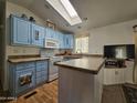 Galley-style kitchen with light blue cabinets and an island at 8700 E University Dr # 1322, Mesa, AZ 85207