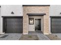 Townhouse entry with brick facade and dark gray garage doors at 2829 W White Feather Ln, Phoenix, AZ 85085