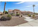 Front yard view of a tan house with a walkway and desert landscaping at 19973 N Half Moon Dr, Surprise, AZ 85374