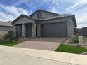 Modern one-story home with stone accents and landscaping at 15935 W Montana De Oro Dr, Surprise, AZ 85387