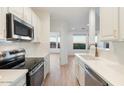 Modern kitchen with white cabinets, stainless steel appliances, and quartz countertops at 12641 N 18Th Pl, Phoenix, AZ 85022