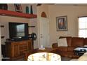 Living room with brown leather sofa, large TV and wood entertainment center at 8500 E Southern Ave # 586, Mesa, AZ 85209