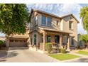 Two-story house with front porch, driveway and garage at 15402 W Old Oak Ln, Surprise, AZ 85379