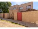 Tan stucco two-story building with red gate and landscaping at 6730 W Monterosa St, Phoenix, AZ 85033